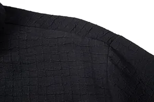 Macro detail view of black jacquard textured fabric on men's summer casual shirt