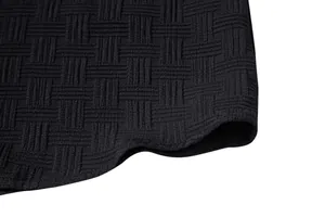 Macro detail of black ethnic style men's shirt showing intricate textured weave pattern