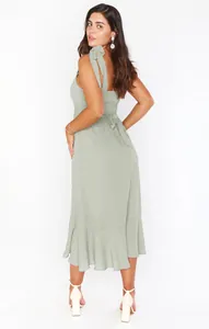 Elegant sage green midi dress with feminine tie-shoulder straps and a ruffled hemline