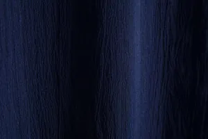 Close-up macro view of navy blue crinkled breathable fabric texture on a men's summer shirt