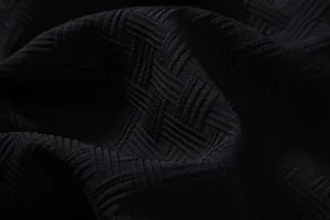 Macro detail of high-quality black textured fabric with a geometric woven pattern