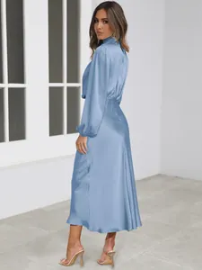 Detail view showing the elegant blue satin long-sleeve dress with a smooth texture.