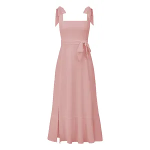 Detail view of an elegant pink French-style midi dress with shoulder bows and side slit