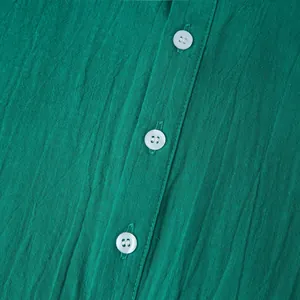 Detailed macro view of the breathable green cotton linen shirt texture with white buttons