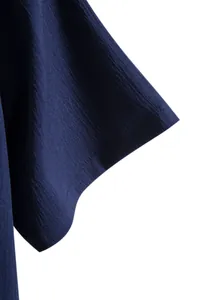 Close-up detail of navy blue crinkle texture fabric on a men's short sleeve shirt sleeve