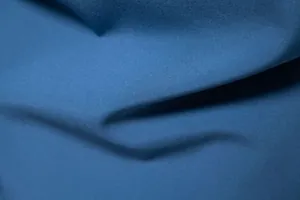 Close-up of premium blue fabric texture for men's solid color casual long sleeve shirt.