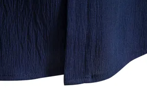 Macro detail of breathable navy blue seersucker fabric and hem stitching on men's shirt.
