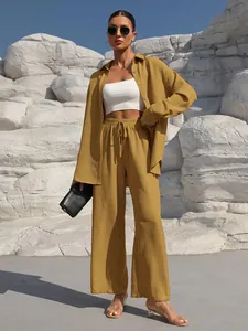 Outdoor model wearing a mustard yellow long sleeve cardigan and wide-leg trouser set