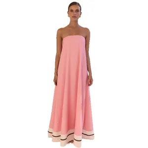 Elegant pink strapless maxi dress with cream and brown striped hem detail for summer events