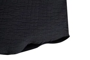 Macro detail of black jacquard seersucker fabric and hem for men's casual shirt