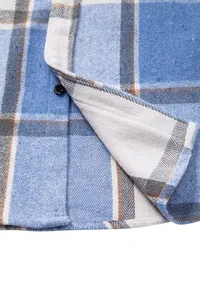 Detalle de camisa gruesa de franela a cuadros azules con textura de tela y botón
