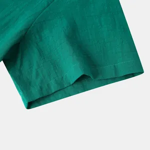 Detail of teal cotton linen shirt sleeve showing fine stitching and fabric texture