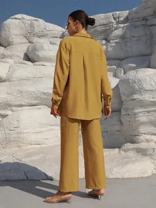Rear view of a mustard yellow long sleeve shirt and wide-leg trousers set in rocky setting