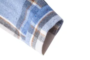 Primer plano del puño de la manga de una camisa de franela a cuadros azules y blancos.