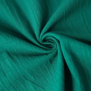 Macro view of green cotton linen fabric texture showing detailed weave and breathable quality