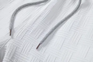 Close-up of white textured seersucker fabric and grey drawstring for men's shirt set