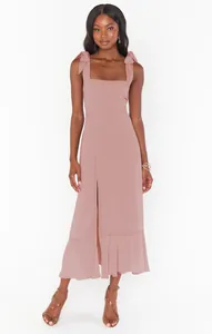 Detailed view of an elegant dusty rose midi dress with tie shoulders and front slit.