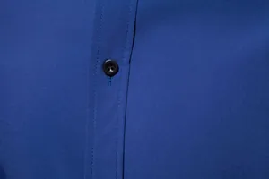Close-up detail of a dark blue men's casual shirt showing the button and fabric texture