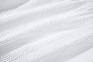 Macro view showing the intricate textured fabric of this white summer men's shirt.