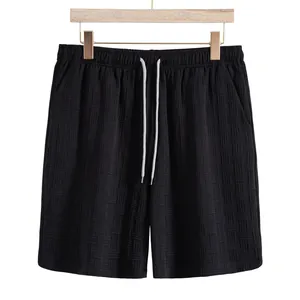 Close-up of black men's shorts featuring a unique waffle texture and adjustable drawstring.