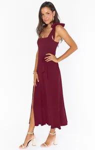 Full-length view of an elegant burgundy split midi dress with shoulder bow ties.