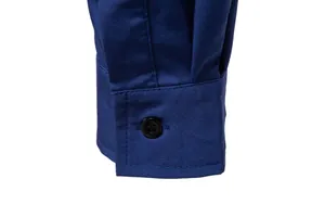 Close-up of a solid blue men's casual long sleeve shirt cuff with a black button