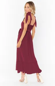 Full-length back view of a wine red maxi dress featuring bow straps and open back detail