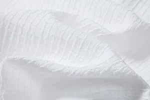 Close-up detail of white jacquard textured fabric for men's casual summer shirt
