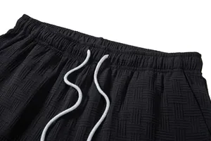 Detail of men's textured shorts featuring elastic waistband and white drawstring