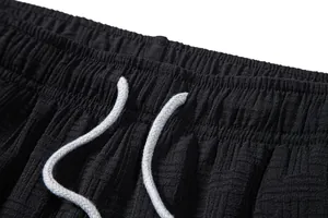Detailed close-up of men's ethnic style shorts with elastic waistband and grey drawstring.