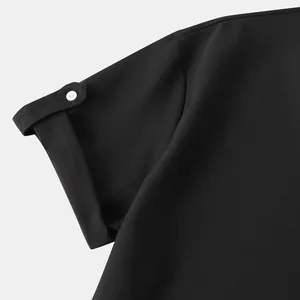 Primer plano del puño de la manga de una camisa negra para hombre con detalle de botón