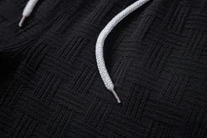 Close-up of black textured fabric and white drawstring on men's ethnic shirt set.