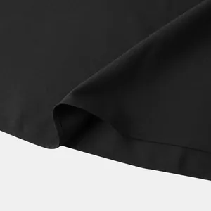 Detalle de tela negra de alta calidad y costuras en camisa de color sólido hombre
