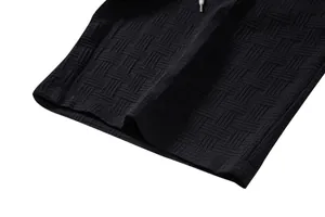 Detailed close-up of the black woven texture fabric on ethnic style men's shorts