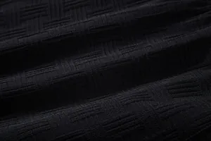 Macro detail of black men's shirt fabric showing ethnic geometric jacquard texture
