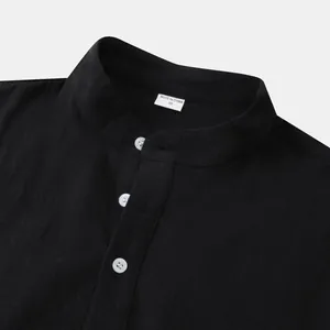 Detail shot of men's black cotton linen shirt with mandarin collar and white buttons.