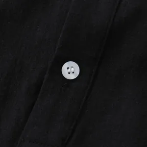 Macro detail of white button and black cotton linen fabric on men's casual shirt