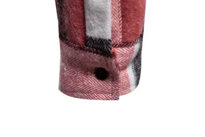Primer plano del puño de una camisa de cuadros roja con tela gruesa de espiga y botón