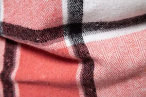 Primer plano de la tela gruesa de camisa de franela a cuadros rojos y blancos con espiga