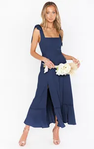 Detailed view of elegant navy blue maxi dress with shoulder ties and high slit.