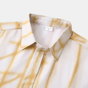 Gros plan du col et de l'imprimé tie-dye jaune sur une chemise à manches courtes