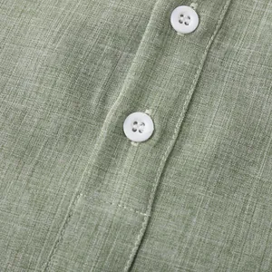 Primer plano detallado de la textura de lino verde claro y botones blancos en camisa de hombre