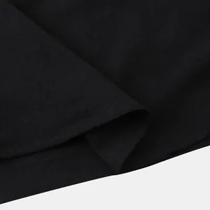 Macro detail of black cotton linen shirt fabric showing texture and hem stitching