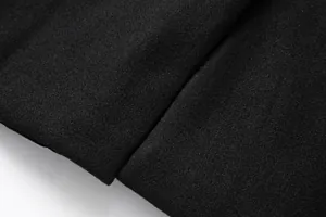 Detaillierte Makroansicht der hochwertigen schwarzen Wollstoffstruktur eines Herrenmantels.