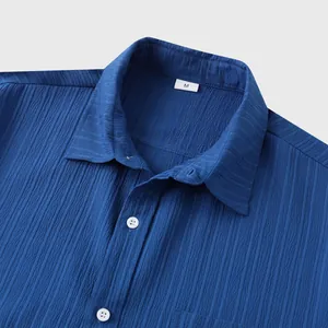 Primer plano del cuello de una camisa azul de manga corta con textura y botones blancos