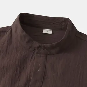 Detail view of brown cotton-linen shirt collar with stand-up design and size S tag.