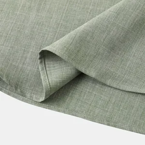 Detalle macro de la textura y costuras de la tela de lino verde de una camisa de hombre