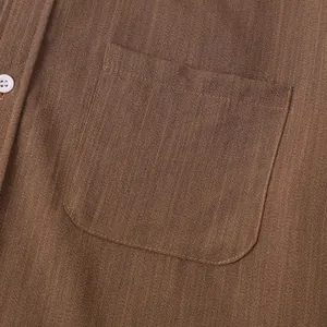 Nahaufnahme des braunen Leinenhemdes für Herren mit Stoffstruktur und Brusttasche.