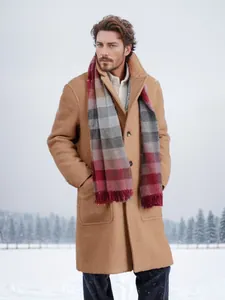 Men's fashionable single-breasted long camel wool overcoat styled in a snowy forest