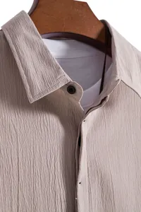 Macro detail of men's summer short sleeve shirt featuring textured crinkle fabric in beige